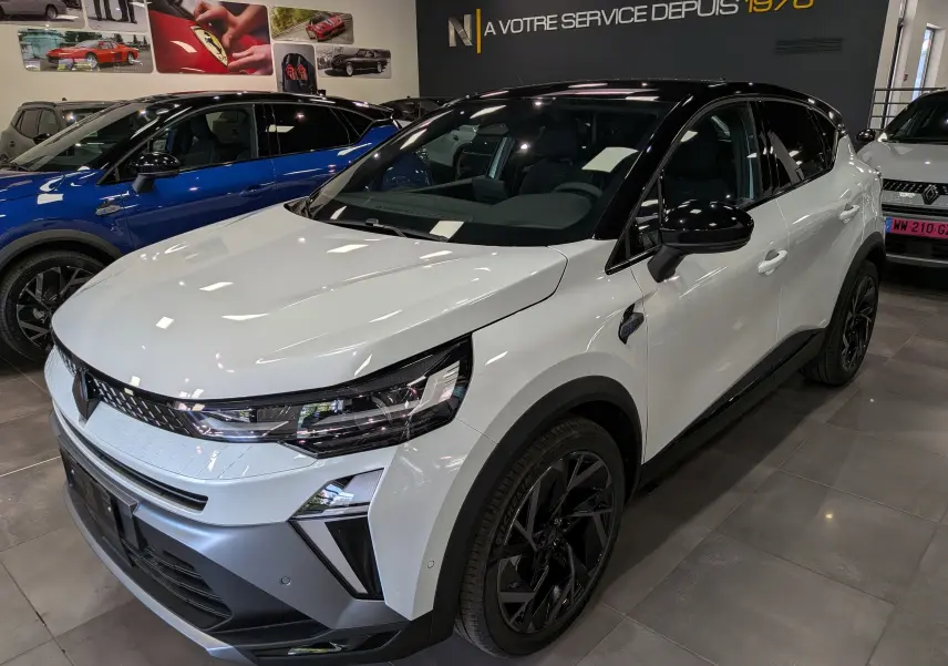 Renault Captur E-Tech blanc nacré avec toit noir, vue 3/4 avant droit, jantes noires et détails modernes.