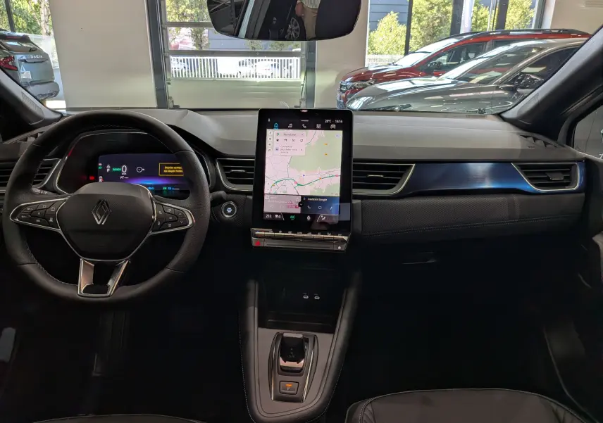 Vue intérieure frontale du tableau de bord du Renault Captur E-TECH 2026 avec écran tactile vertical et volant multifonction.