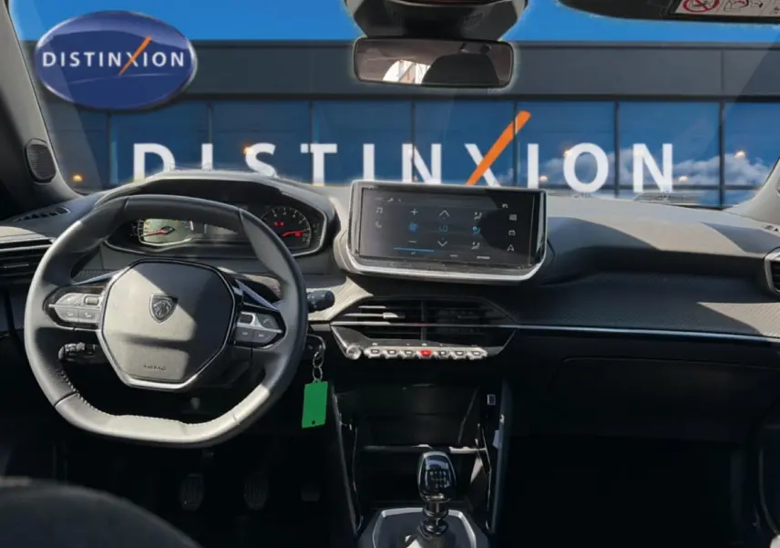Vue intérieure avant du Peugeot 2008 gris 2025, avec tableau de bord moderne et écran tactile central.