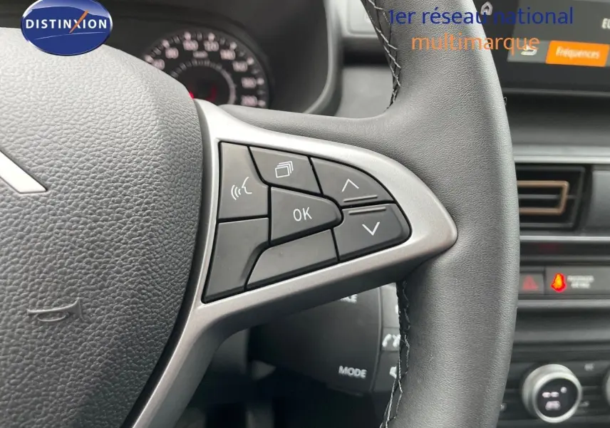 Gros plan sur les commandes au volant en cuir noir du Dacia Jogger 2024, avec écran tactile et tableau de bord partiel visible.