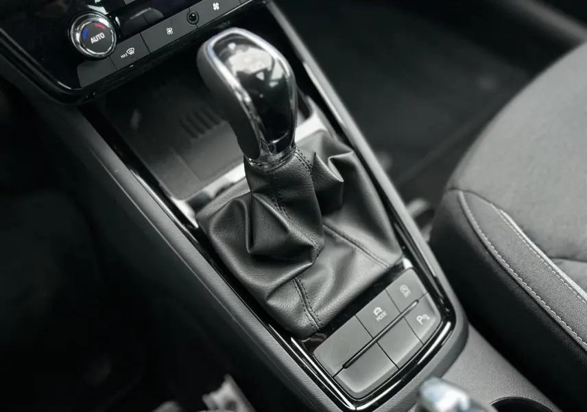 Gros plan sur la console centrale du Skoda Kamiq noir Magic 2025, avec levier de vitesses automatique et boutons de contrôle.