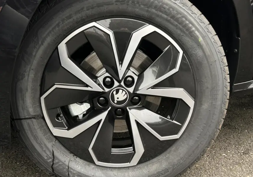Gros plan sur la jante alliage noire et argentée du côté avant droit d’un Skoda Kamiq Noir Magic.