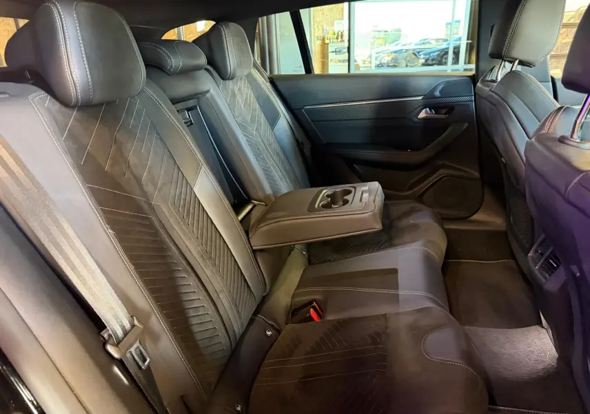 Vue intérieure côté droit des sièges arrière noirs en Alcantara avec accoudoir central et surpiqûres Aikinite Peugeot 508 SW 2024.