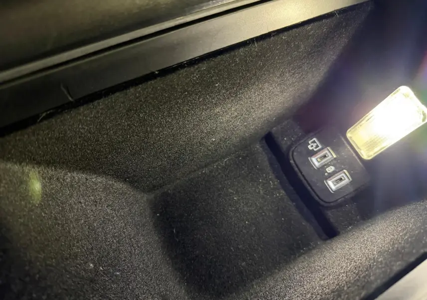 Gros plan sur le rangement central avant noir avec prises USB et éclairage intérieur dans une Peugeot 508 SW 2024.