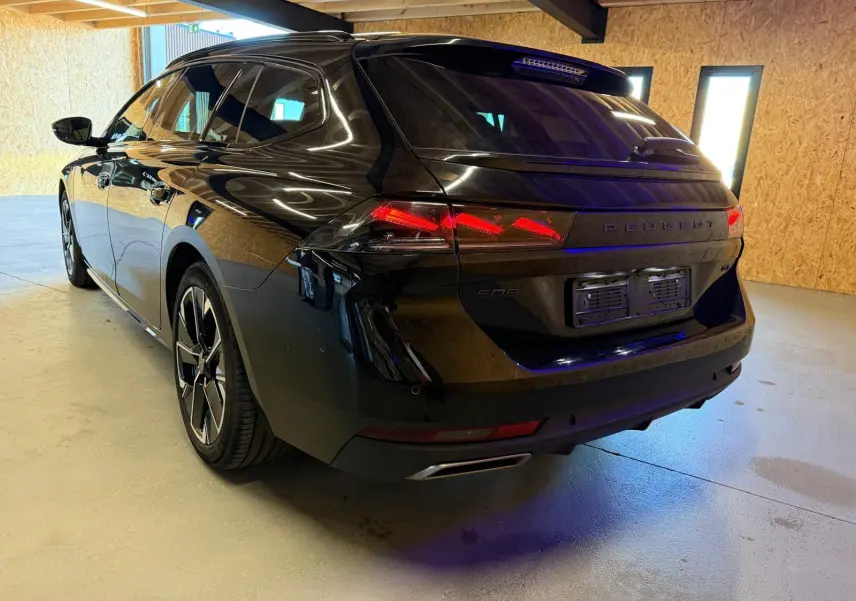 Peugeot 508 SW noire vue 3/4 arrière droit, avec feux arrière LED et jantes alliage 18 pouces bi-ton.