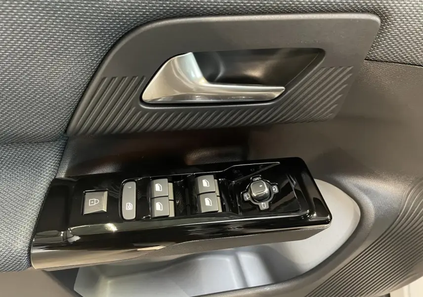 Gros plan sur la commande de lève-vitres et rétroviseurs côté conducteur du Citroën C5 Aircross 2026 noir et gris.