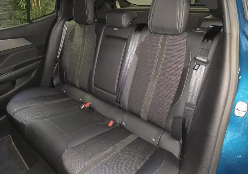Vue latérale droite de la banquette arrière en tissu et cuir noir de la Peugeot 408 bleu métallisé 2024.