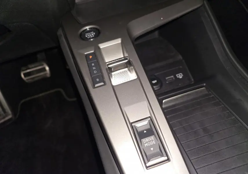Gros plan sur la console centrale grise avec levier de vitesses électronique et bouton Drive Mode du Peugeot 408 2024.