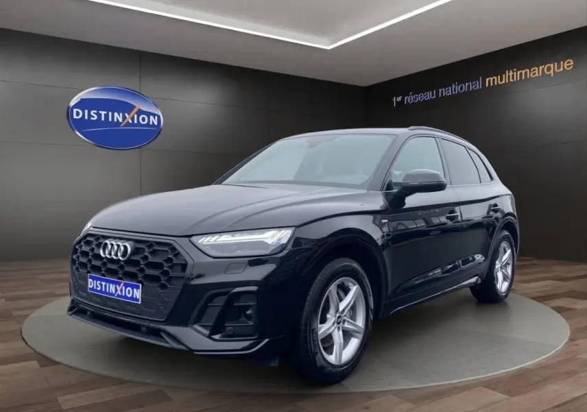 Audi Q5 noir en vue 3/4 avant droit, avec calandre hexagonale noire et jantes argentées cinq branches.