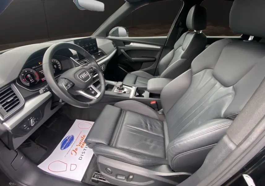 Vue intérieure côté conducteur de l'Audi Q5 35 TDI 2022 avec sièges cuir noirs et tableau de bord digital.