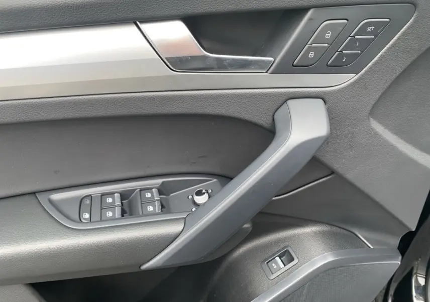Détail de la porte avant gauche noire d’Audi Q5 35 TDI 2022 avec commandes des vitres et verrouillage centralisé.