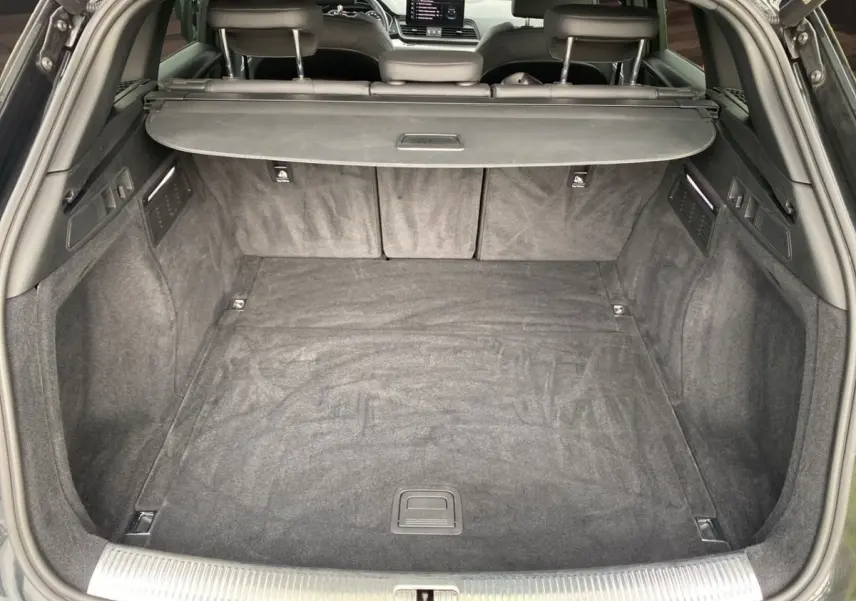 Coffre ouvert vu de l'arrière d'un Audi Q5 noir 35 TDI 2022, avec banquette arrière et cache-bagages visibles.
