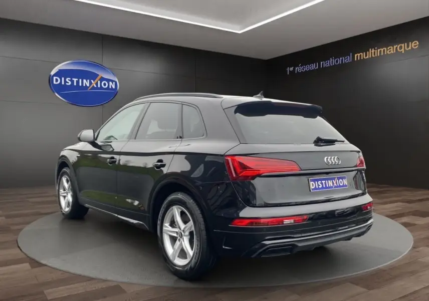 Audi Q5 35 TDI S Line noir en 3/4 arrière droit, avec feux LED et jantes alliage visibles en showroom.