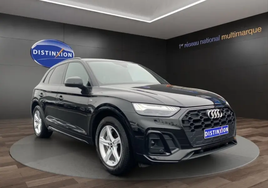 Audi Q5 noir en 3/4 avant droit, avec calandre hexagonale noire et jantes argentées cinq branches.