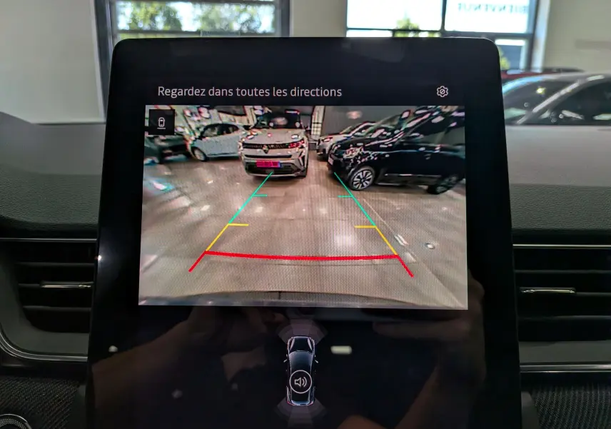 Écran central affichant la caméra de recul du Renault Captur E-Tech bleu Iron avec toit noir, vue arrière en intérieur.