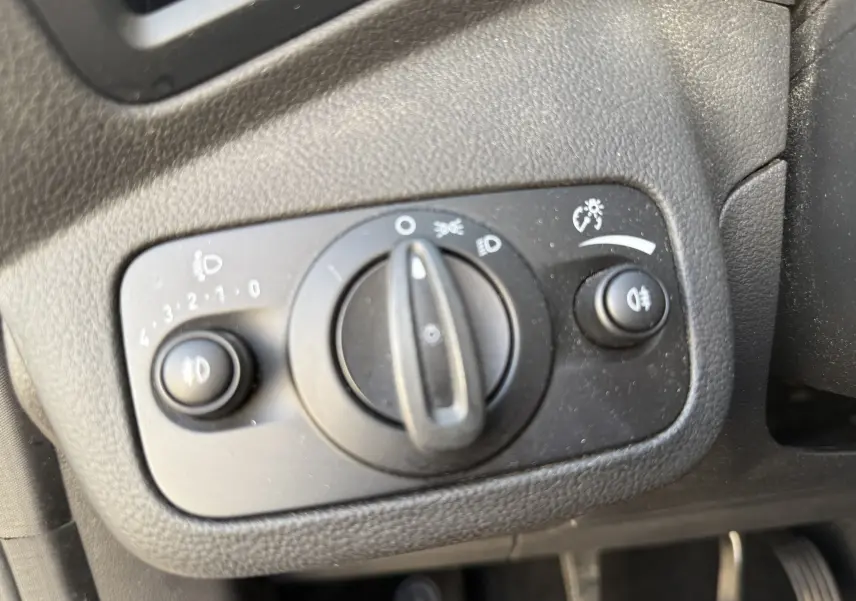 Gros plan sur le panneau de commande des phares noir dans l'habitacle du Ford C-MAX vert 2018, version Titanium.