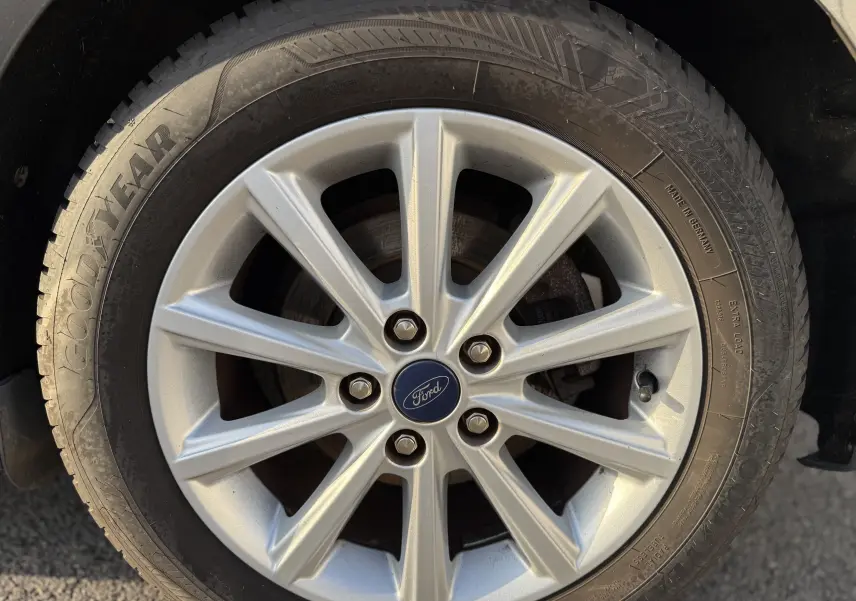 Gros plan sur la roue avant droite d'une Ford C-MAX 1.6 TDCI 120 Titanium avec jante alliage argentée et pneu Goodyear.