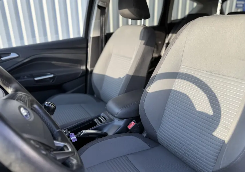 Vue intérieure rapprochée des sièges avant gris tissu du Ford C-MAX 1.6 TDCI 2018 avec levier de vitesse manuel visible.