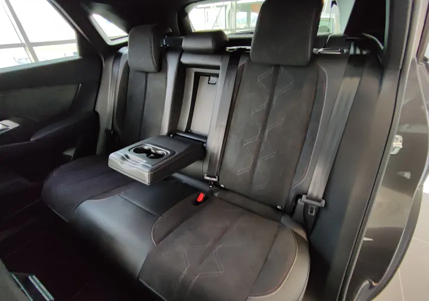 Vue intérieure sur les sièges arrière noirs du DS7 Crossback E-TENSE 2022 avec accoudoir central et porte-gobelets déployé.