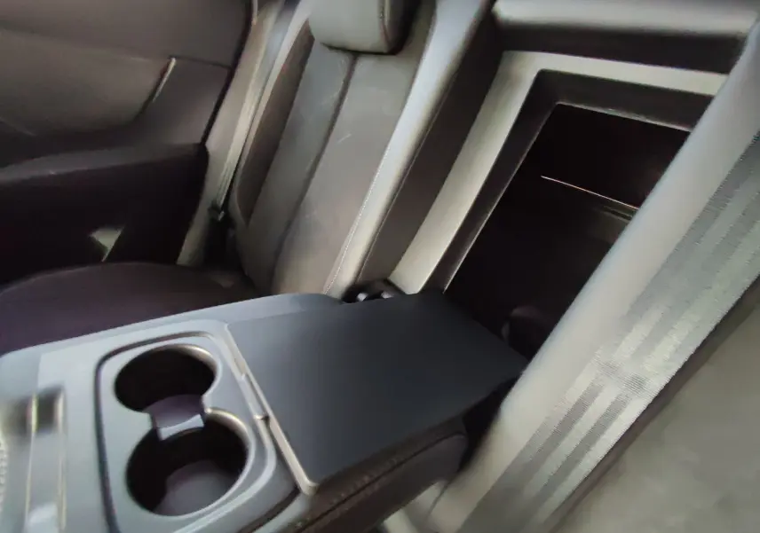 Intérieur arrière du DS7 Crossback gris 2022, vue sur l'accoudoir central avec porte-gobelets et sièges en cuir.