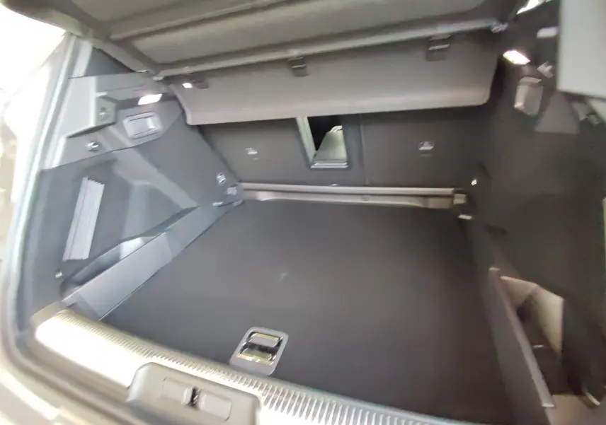 Coffre spacieux du DS7 Crossback gris, vue intérieure arrière avec banquette rabattue et finition noire.