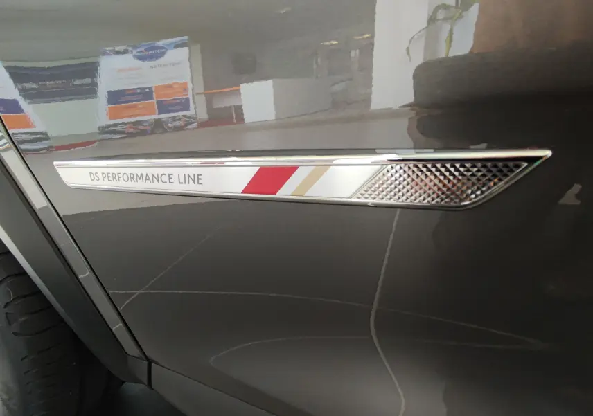 Détail de l'aile avant gauche gris métallisé du DS7 Crossback 2022 avec l’inscription DS Performance Line.
