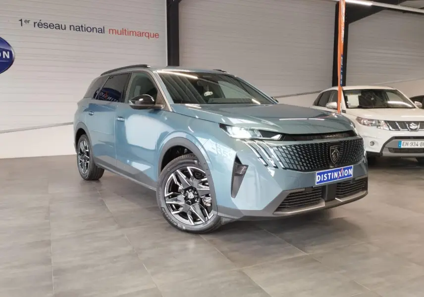 Peugeot 5008 bleu Ingaro en 3/4 avant droit, avec calandre noire et jantes alliage 19 pouces diamantées.