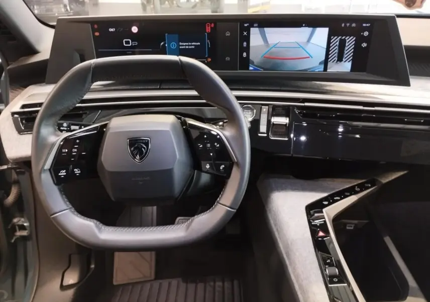 Vue intérieure du poste de conduite du Peugeot 5008 2025, volant compact et double écran HD panoramique.