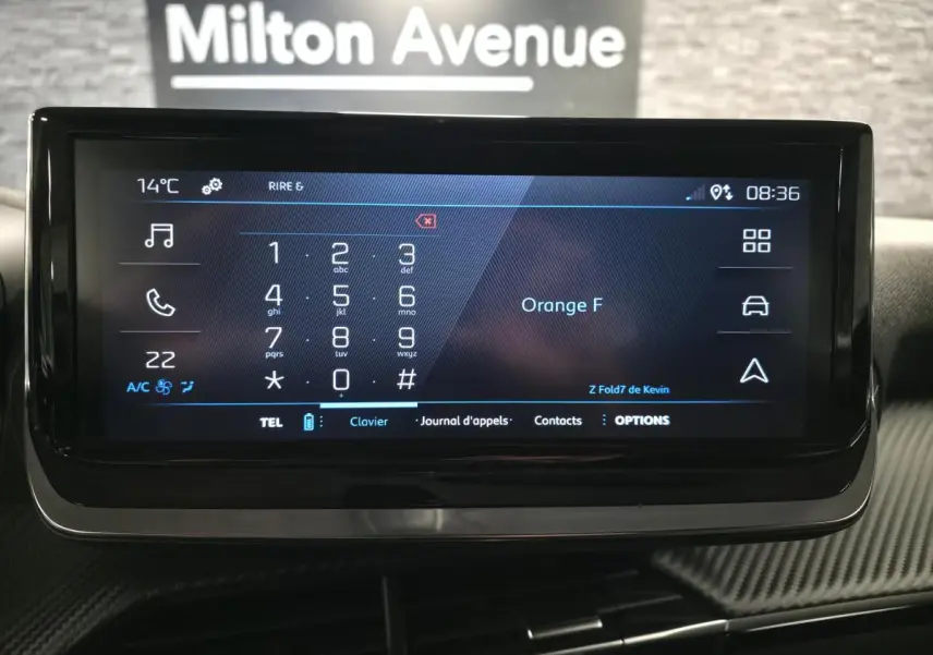 Écran tactile central du Peugeot 2008 2025 affichant le clavier téléphonique, avec décor carbone autour.