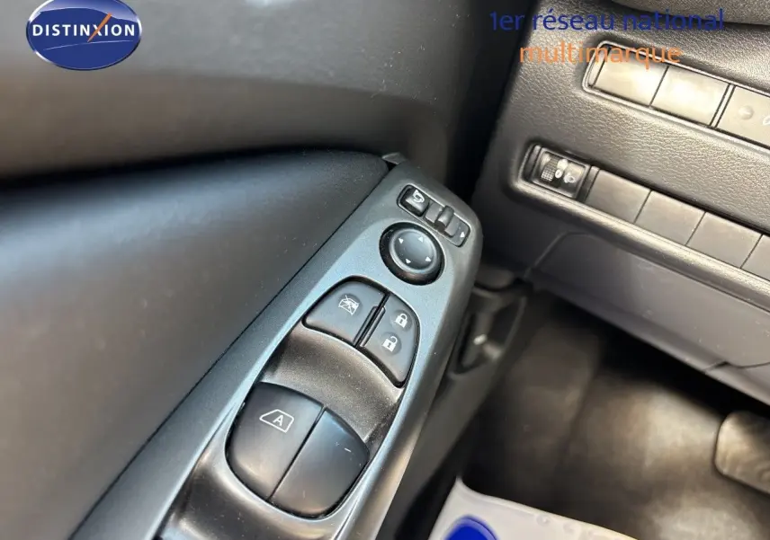 Détail des commandes de lève-vitres et rétroviseurs côté conducteur dans l’habitacle noir du Nissan Juke Hybrid 2024.