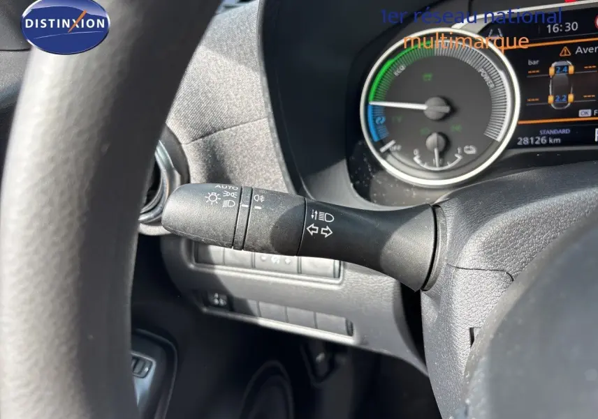 Gros plan sur la manette des clignotants à gauche du volant du Nissan Juke Hybrid 2024 avec tableau de bord numérique visible.