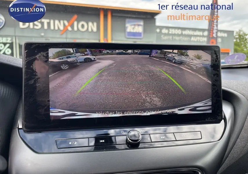 Vue intérieure de l'écran multimédia affichant la caméra de recul du Nissan Juke gris squale metal 2024 en stationnement.