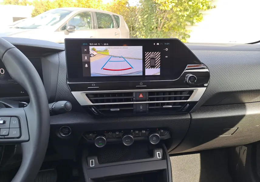 Tableau de bord intérieur de Citroën C4 hybride 2025 avec écran central affichant la caméra de recul.