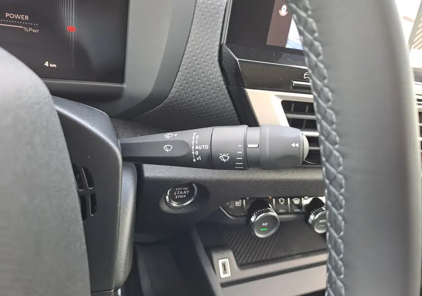 Gros plan sur la commande d’essuie-glace et le bouton start/stop du tableau de bord intérieur de la Citroën C4 hybride 2025.