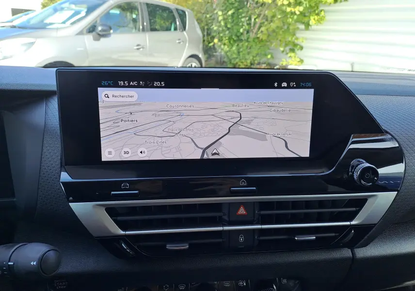Écran tactile central du tableau de bord de la Citroën C4 hybride 2025, affichant la navigation GPS en extérieur lumineux.