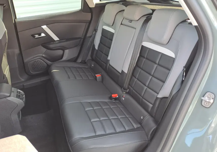 Vue côté droit des sièges arrière en cuir noir et gris de la Citroën C4 hybride 2025 Manhattan Green.