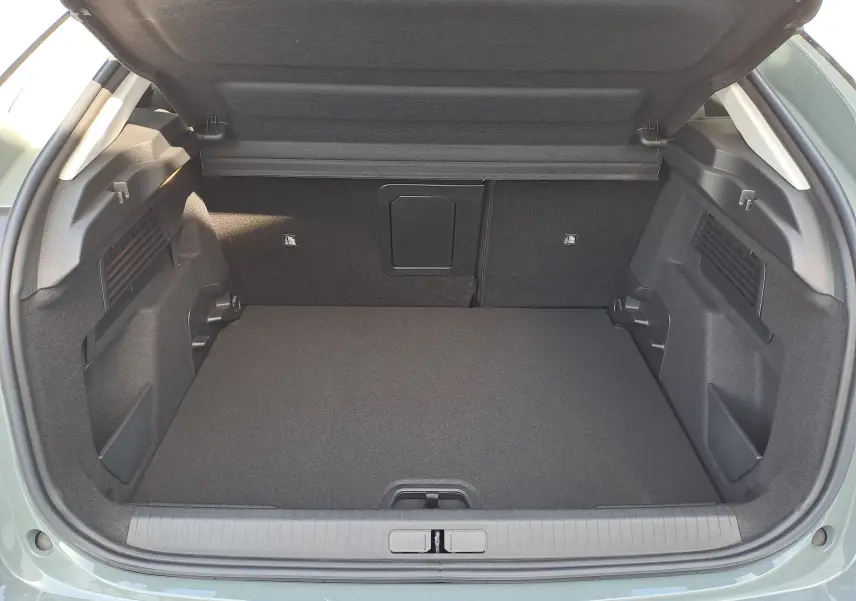 Coffre ouvert vu de l'arrière d'une Citroën C4 hybride 2025 Manhattan Green avec intérieur noir épuré.