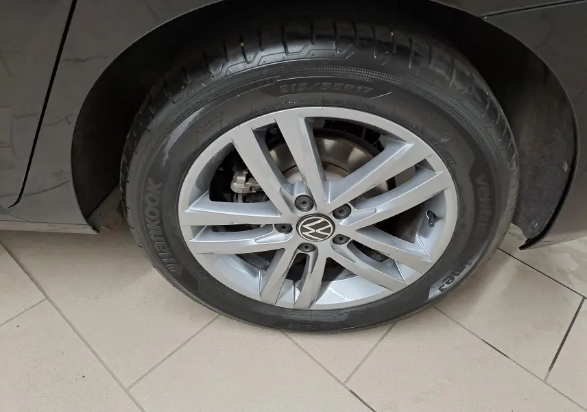 Gros plan sur la roue avant droite du Volkswagen Touran noir Grenadille, avec jante alliage à 10 branches.