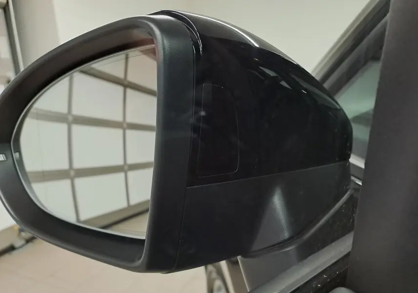 Rétroviseur extérieur droit noir grenadille du Volkswagen Touran 2025, vue rapprochée en intérieur de garage.