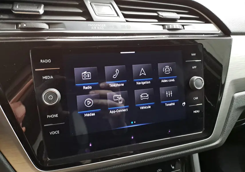 Écran tactile central du tableau de bord du Volkswagen Touran 2025, affichant les options multimédia et navigation.