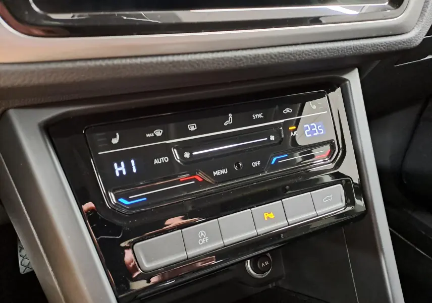 Gros plan sur la console centrale du Volkswagen Touran 2025, affichage numérique de la climatisation et boutons de commande.