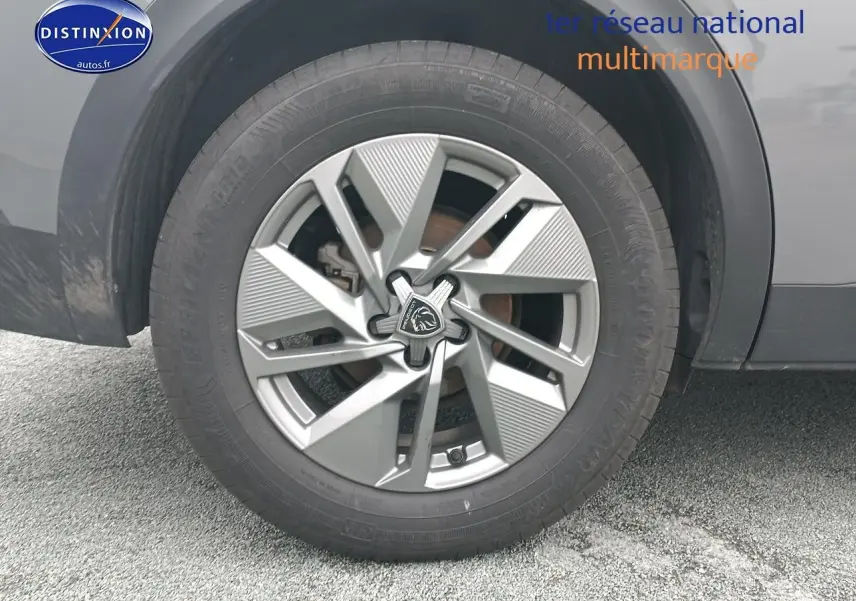 Gros plan sur la jante alu grise et le pneu d'un Peugeot 408 Hybrid 145 allure e-dcs6 gris sellenium e.