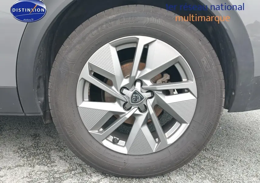 Gros plan sur la jante alu grise avec logo Peugeot d’un PEUGEOT 408 gris sellenium, vue côté droit.