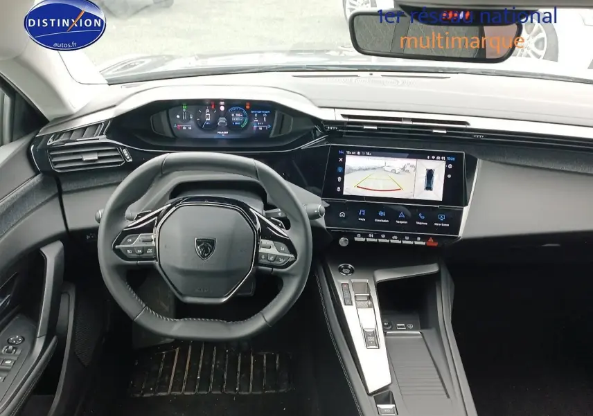 Intérieur Peugeot 408 Hybrid 2024 vu de face, volant cuir multifonction et écran tactile avec caméra de recul.