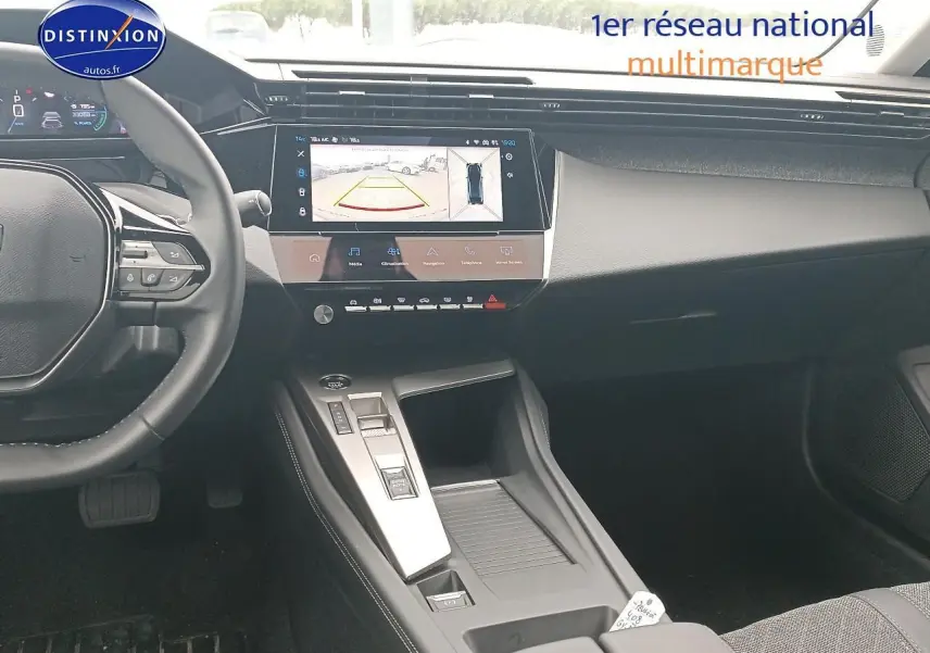 Vue intérieure avant de la Peugeot 408 Hybrid 145 allure 2024, tableau de bord moderne avec écran tactile et console centrale grise.