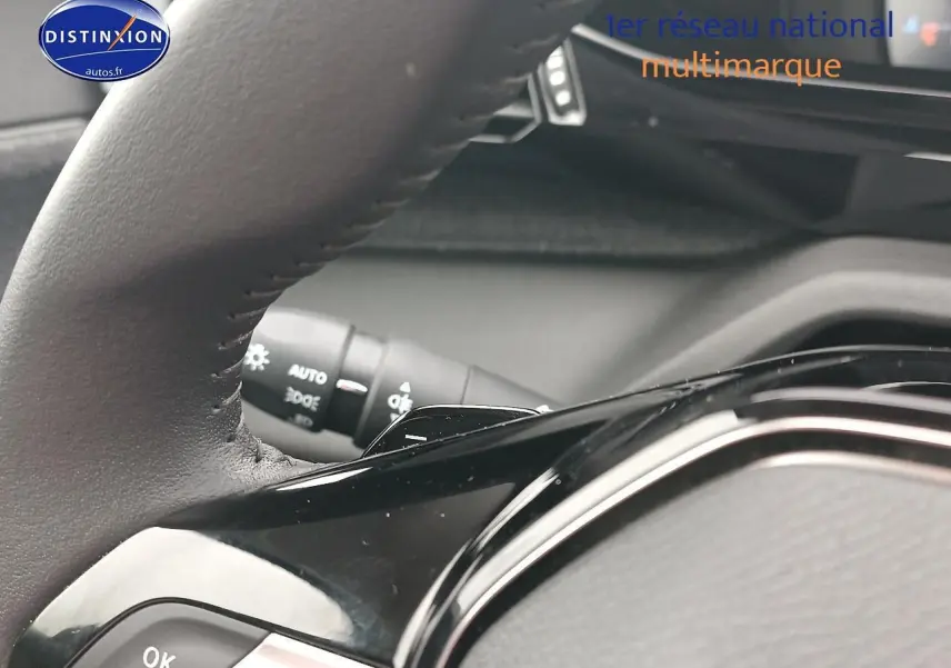 Gros plan sur le volant cuir multifonction noir de la Peugeot 408 Hybrid 145 allure 2024, avec commandes intégrées.