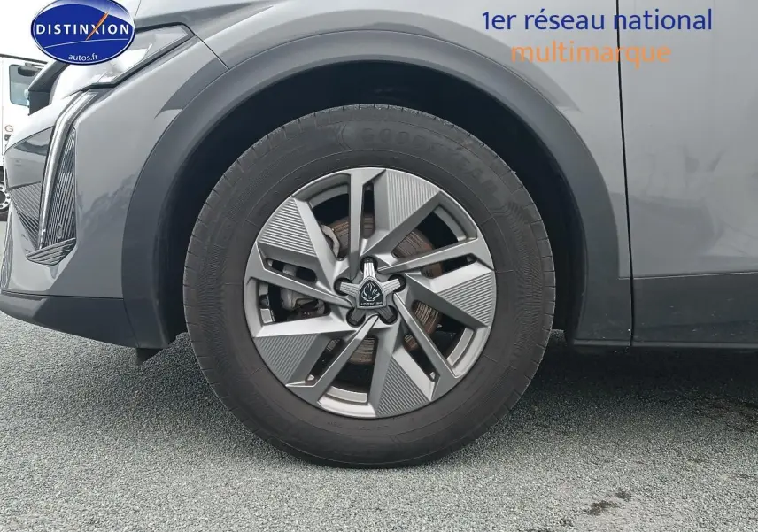 Gros plan sur la roue avant gauche de la Peugeot 408 Hybrid 145 allure gris sélénite avec jante alu au design moderne.