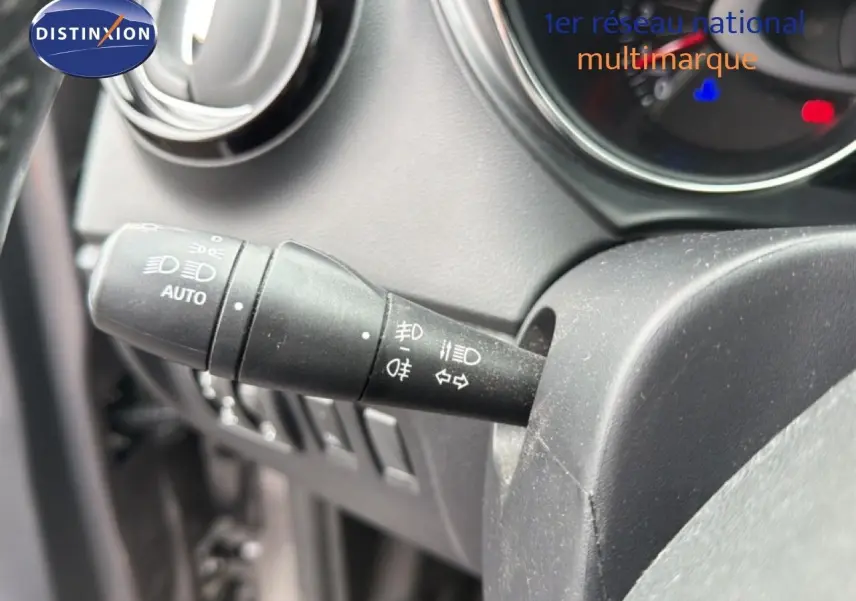 Gros plan sur la commande des phares et clignotants du tableau de bord d’un Renault Captur gris.