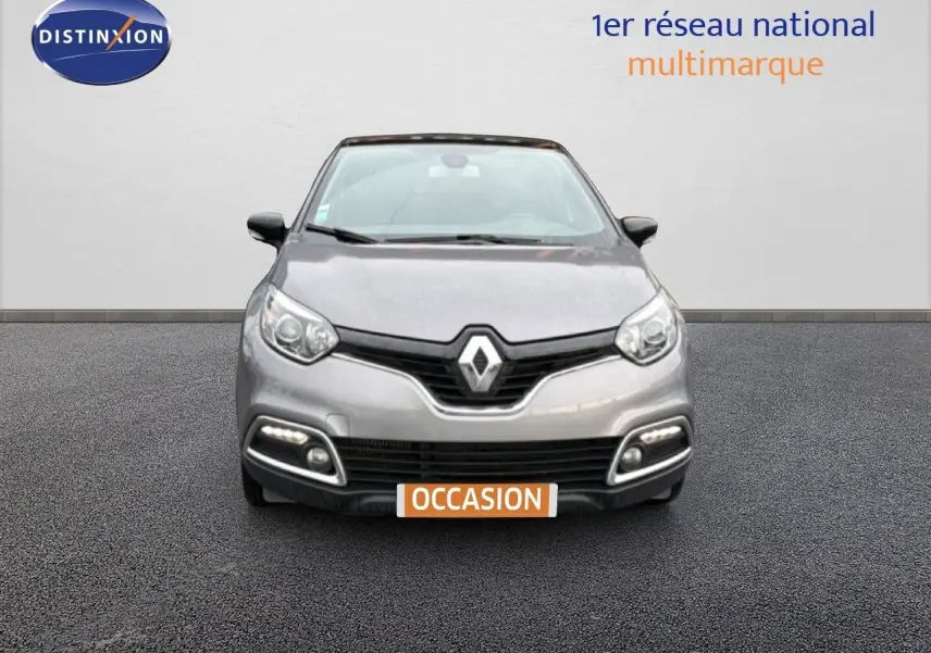 Vue frontale d'une Renault Captur gris Cassiopée avec toit noir étoilé, feux diurnes LED allumés, sur fond neutre.