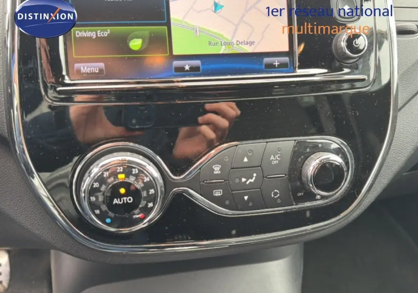 Gros plan sur la console centrale noire brillante du Renault Captur 2016 avec commandes climatisation et écran tactile GPS.